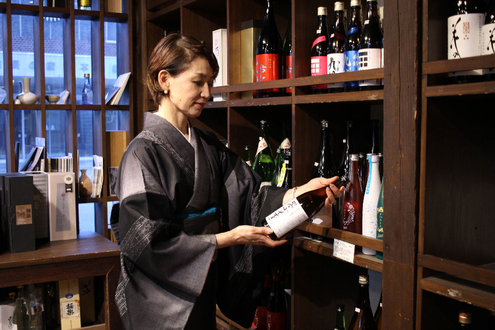 お酒を選ぶ川上酒店の奥様