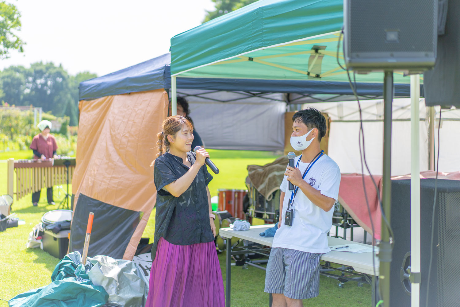 マイクを持っている土山さんと女性が会話している写真